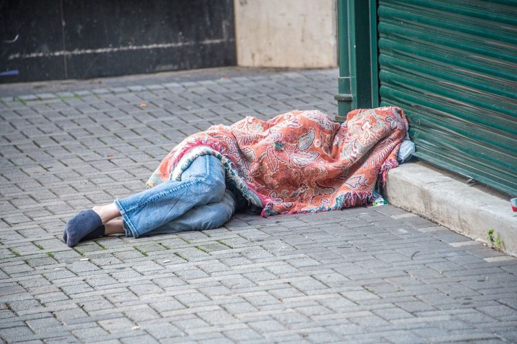 Homeless man sleeping on footpath