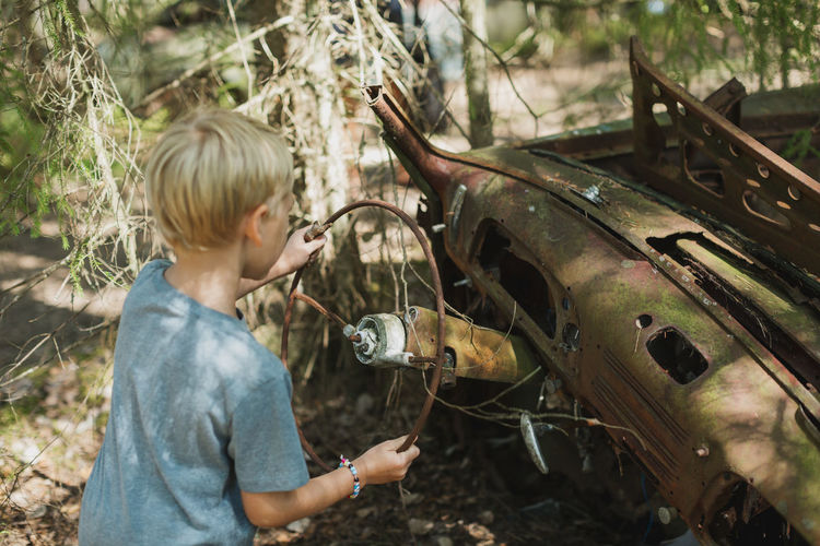 Boy playing in wrecked car