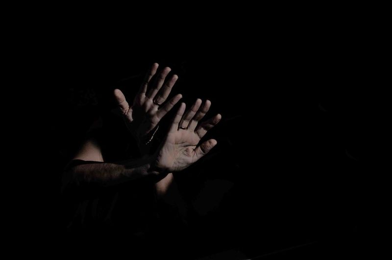 Human hand against black background