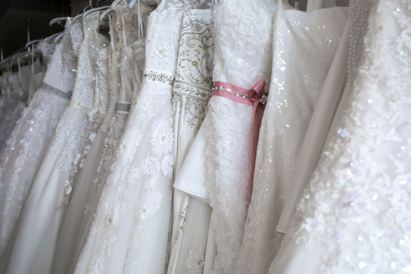 White dresses hanging in row for sale at clothing store