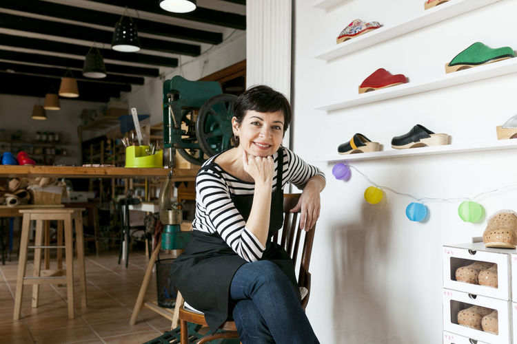 Portrait of confident clogmaker in her workshop