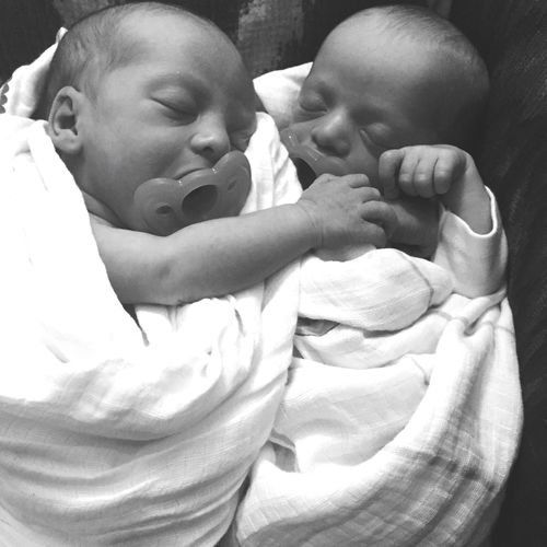 Close-up of newborn twins wrapped in blanket