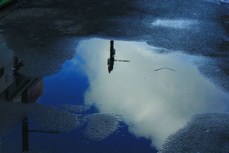 Sky reflection on puddle during winter