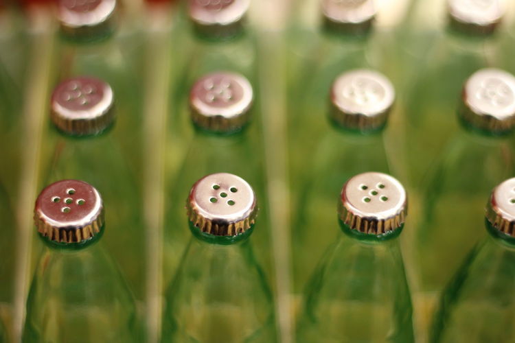 High angle view of bottles with holes in lids