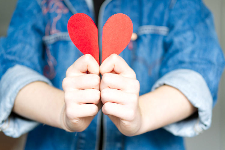 Midsection of woman holding heart shape