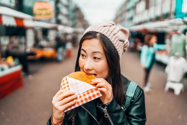 Woman eating food in city