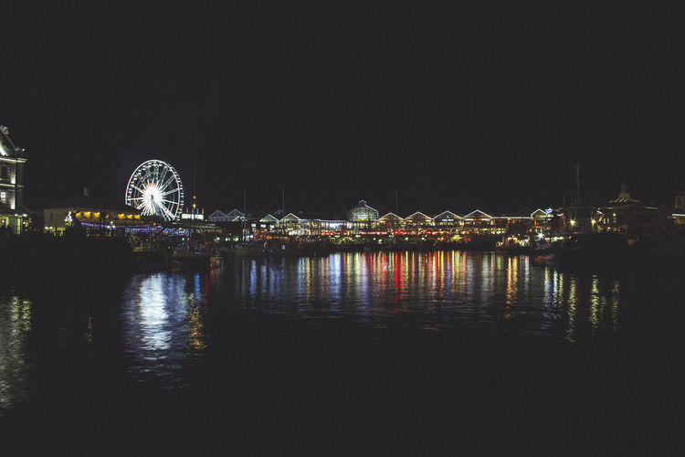 Illuminated ferris wheel in city at night