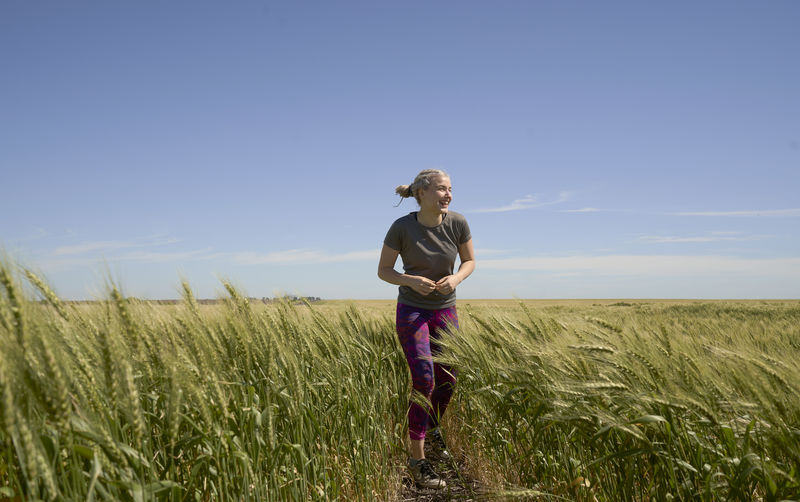 Full body of young woman runner background agriculture field