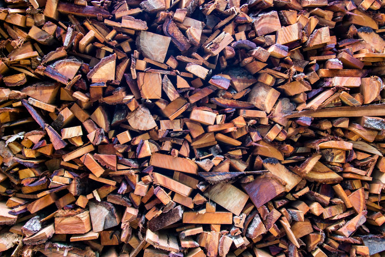 Firewood wooden logs big chopped trunks stacked pile dry for the used fireplace in winter.