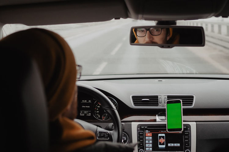 Millennial man drive the car and using mobile app , green screen. high quality photo