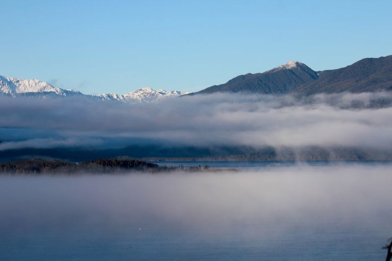 Fog over snowcapped mountain range