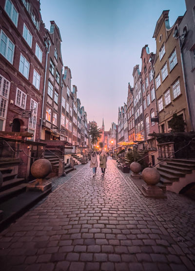 People on street amidst buildings in city