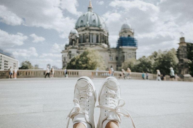 Low section of man wearing shoes against berlin cathedral