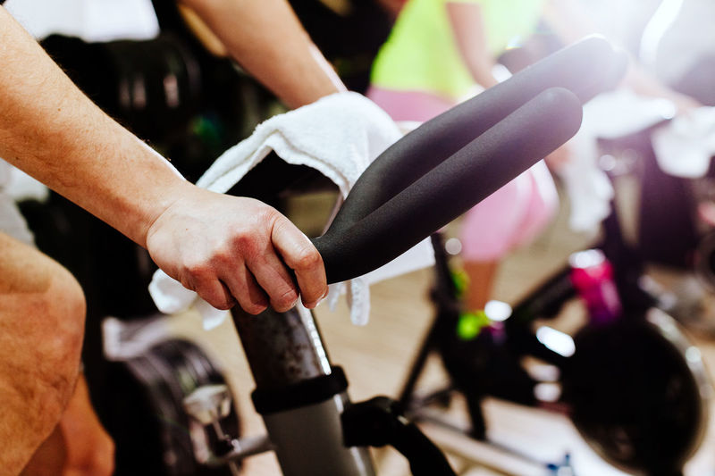 Cropped hands using exercise bike at gym