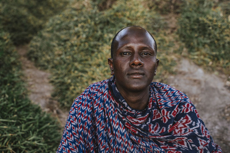 Maasai man sitting at the beach in front of the indian ocean