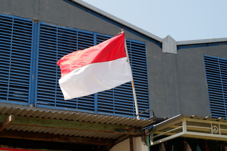 Low angle view of indonesian flag against building