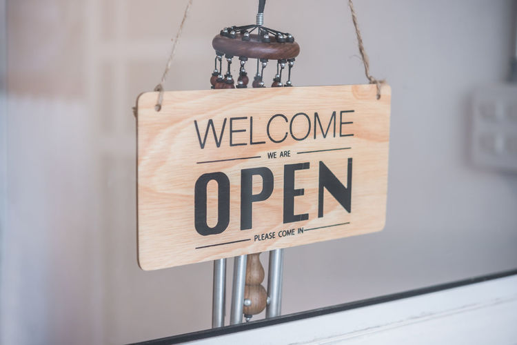 Close-up of open sign seen through glass window