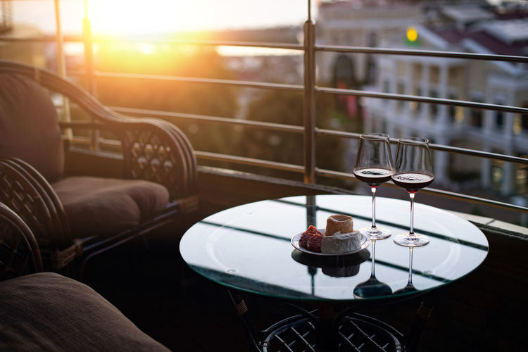 View from the balcony to the sea and sunset. a romantic evening for two. two glasses of red wine 
