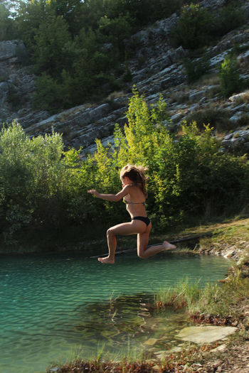 Young woman jumpin in a lake