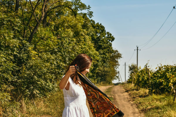 Woman standing on field against trees