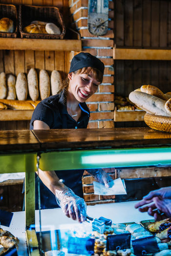 Smiling young woman working at bakery
