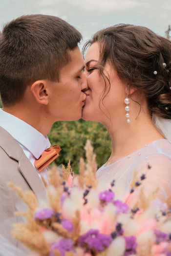 Young couple kissing with flowers
