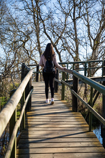 Low angle view of woman walking on footbridge