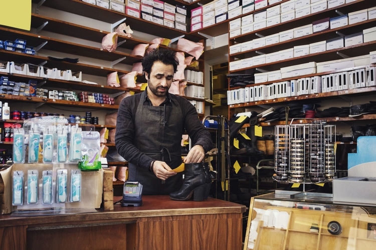 Owner reading name tag while standing at shoe store