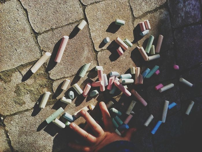 Cropped image of child playing with colorful chalks