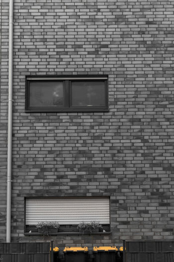 Low angle view of brick wall against building