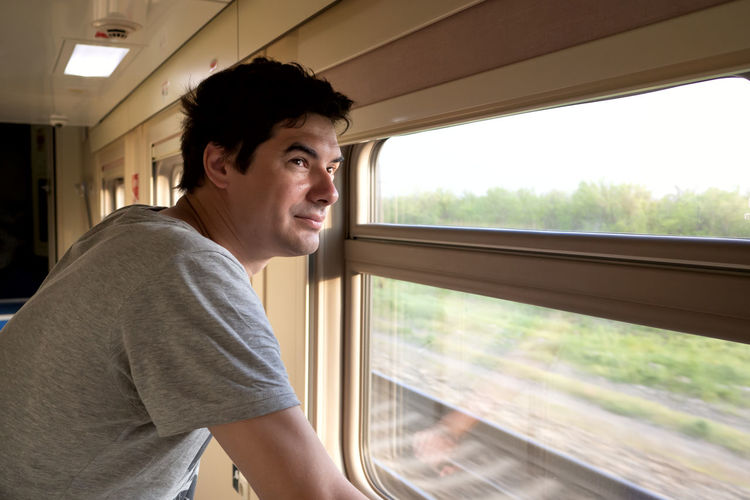 Man travels alone by train and looks out