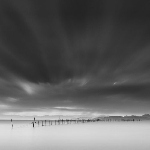 Long exposure shot of wooden sticks in the water, lake biwa, shiga prefecture, japan