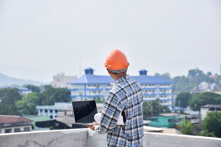 Man working at construction site against sky