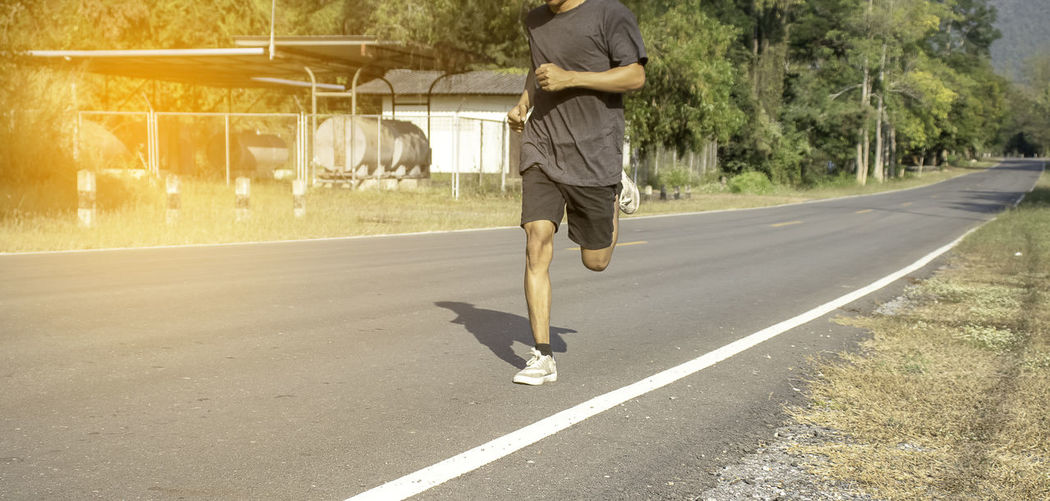 Low section of man running on road