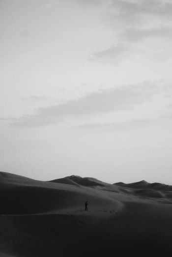 Silhouette person on desert against sky