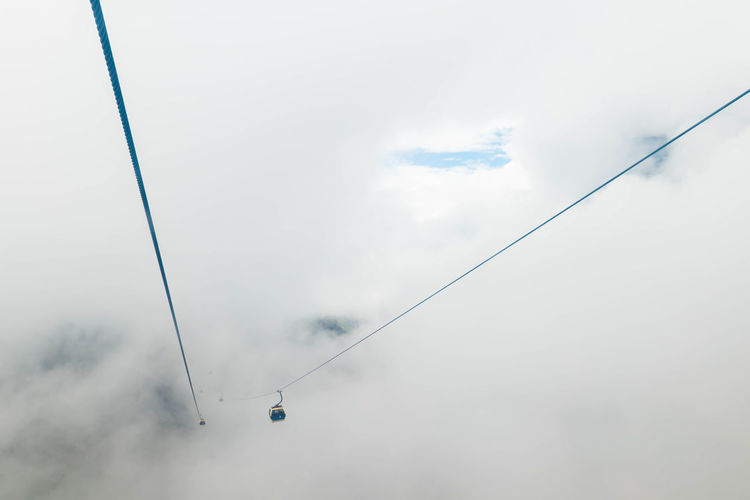 Overhead cable car amidst clouds