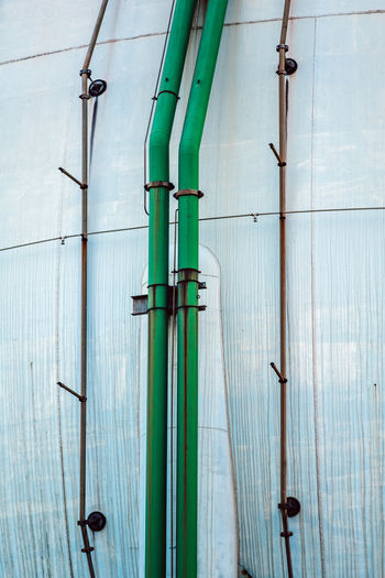 Green thin pipes attached to metal spherical fuel deposit in detail