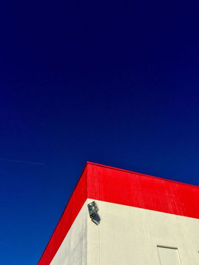 Low angle view of red built structure against blue sky