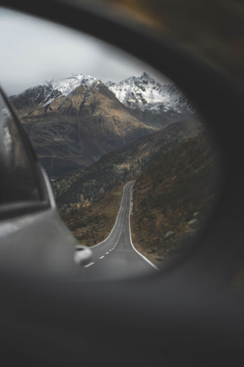 Reflection of mountain seen through car window