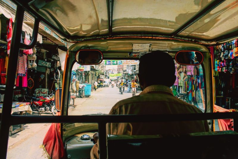 Rear view of driver driving rickshaw