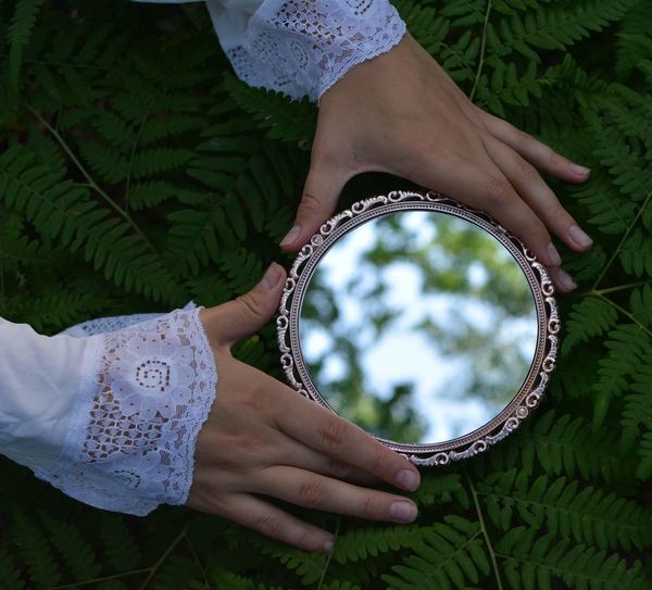 Woman with a mirror in the forest