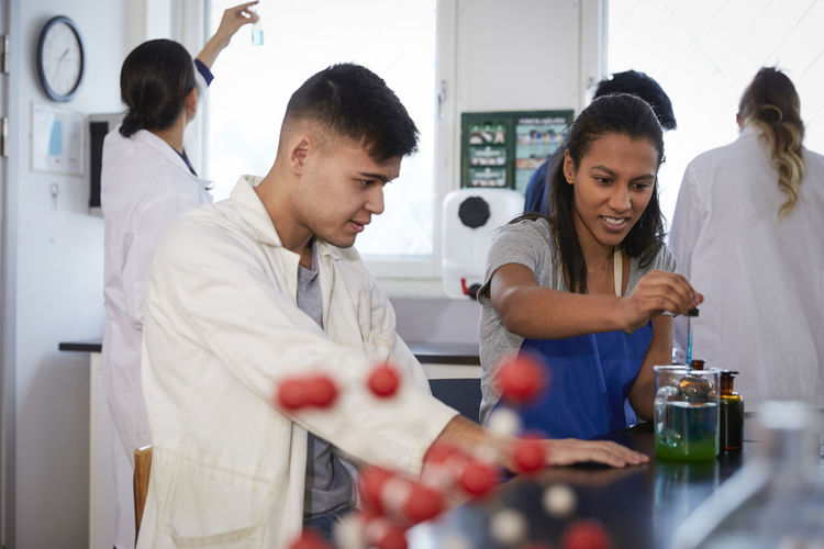 Multi-ethnic chemistry students with teacher in laboratory at university