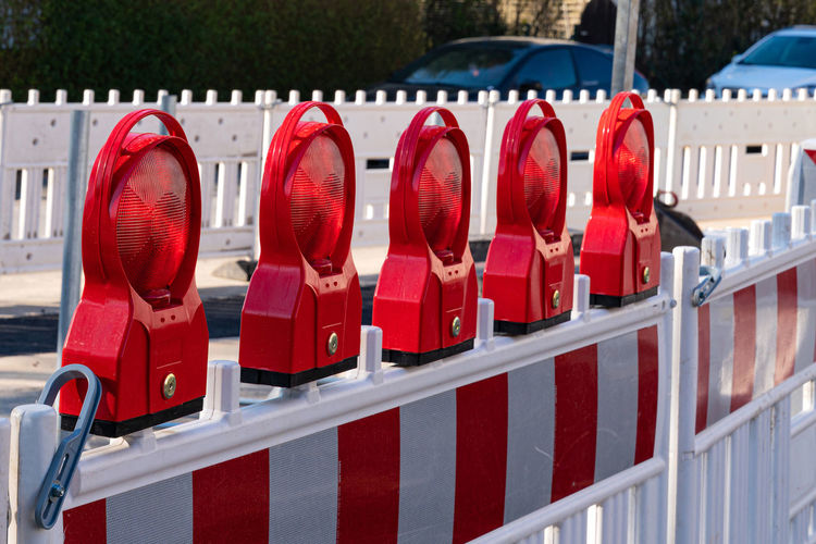 Construction plastic barrier at a road with red reflecting lamps as safety installation.