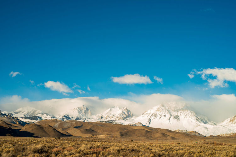 Scenic view of snowcapped mountains against blue sky