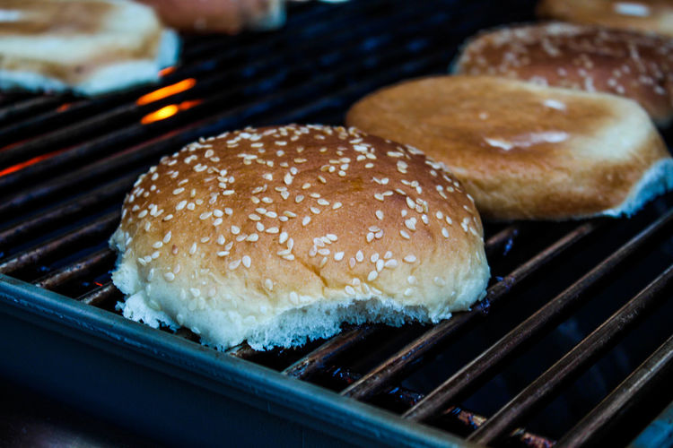 Grilling hamburger buns with sesame seeds on grill. 