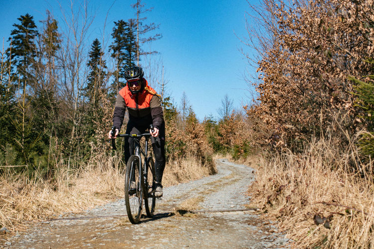 Woman riding bicycle on gravel road