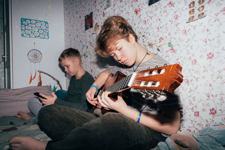 Side view of boy playing guitar
