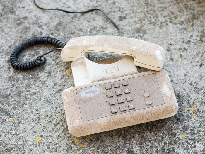 Close-up of abandoned telephone on rock