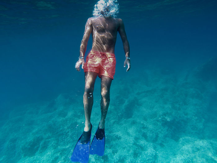 Rear view of man swimming in sea