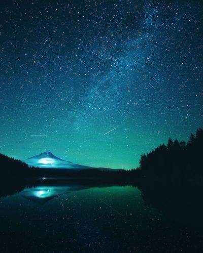 Scenic view of lake against clear sky at night